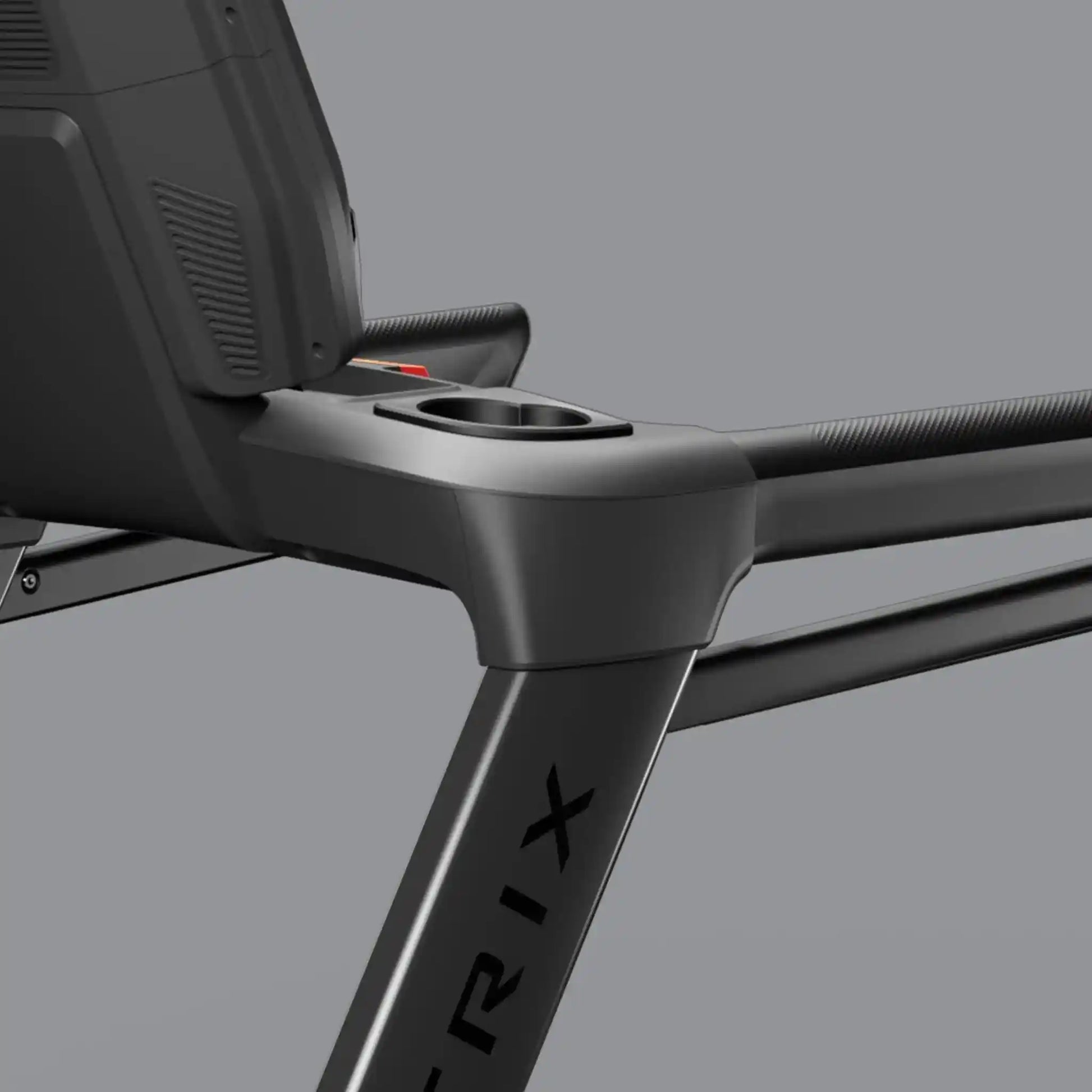 Close-up of a black treadmill with cup holder on a grey background