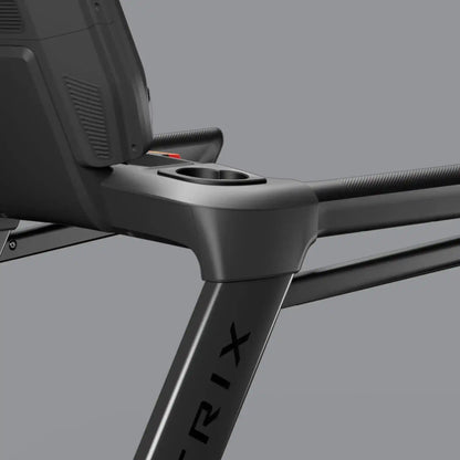 Close-up of a black treadmill with cup holder on a grey background