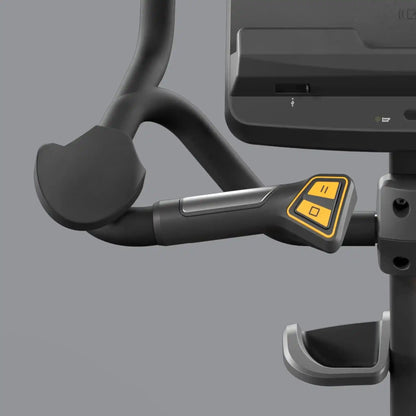 Close-up of a handlebar with control buttons on a exercise bike against a grey background