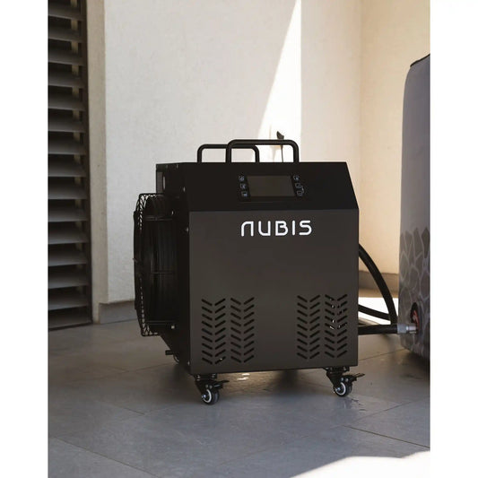 Black Nubis ice bath chiller on wheels on patio with light-colored walls in the background