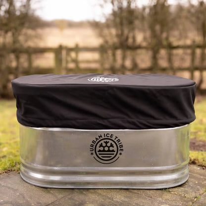 Steel ice bath and black cover, with Urban Ice Tribe branding, in a garden setting. 